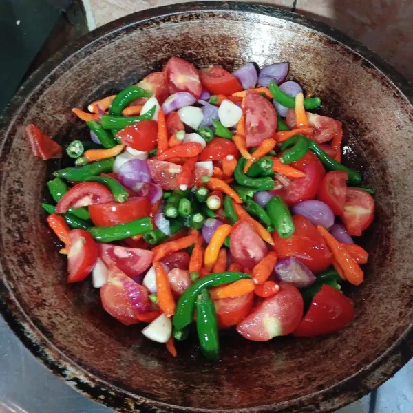 Panaskan minyak goreng, masukkan cabai merah, cabai rawit, dan bawang merah serta bawang putih.