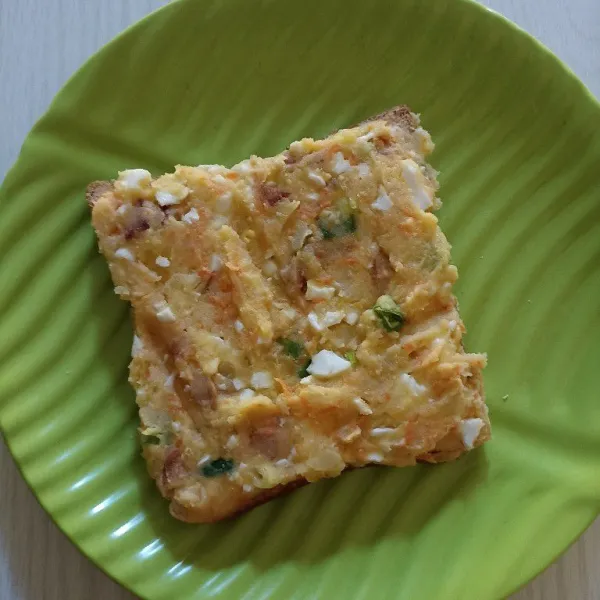 Ambil 1 lembar roti tawar. Beri permukaan atas roti dengan adonan isian merata.