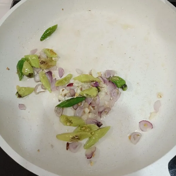 Tumis bawang merah, bawang putih dan cabai dengan sedikit minyak sampai harum.