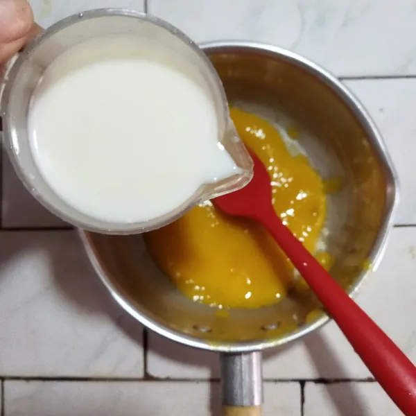 Siapkan panci, masukkan gula pasir, garam, dan bubuk jelly, lalu aduk rata. Tambahkan susu dan mangga yang sudah dihaluskan, kemudian aduk hingga tercampur rata.
