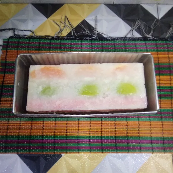 Keluarkan puding buah dari loyang ukuran 5x18 cm, kemudian masukkan ke dalam loyang berisi puding cokelat.