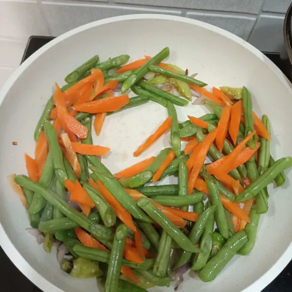 Masukkan sayuran buncis dan wortel yang sudah dicuci bersih lalu tumis sampai merata.