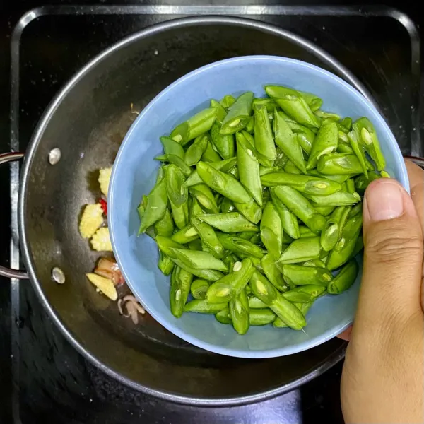 Tambahkan buncis, lalu tambahkan air. Aduk-aduk hingga layu.