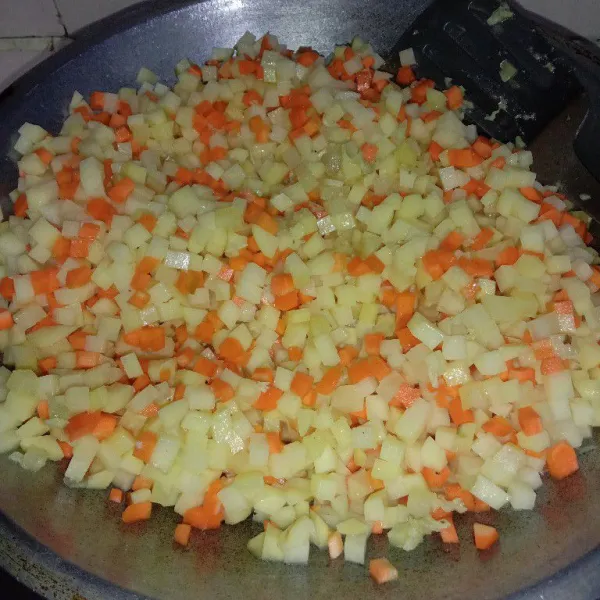 Masukkan kentang dan wortel tambahkan air lalu aduk-aduk, masak sampai kentang + wortel mateng dan air asat.