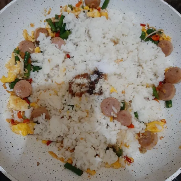 Masukkan nasi dan beri bumbu perasa.