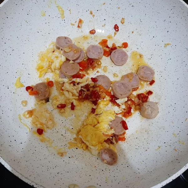 Masukkan telur dan sosis. Orak arik semuanya.