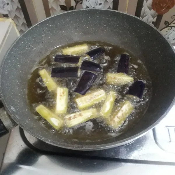 Cuci bersih dan potong-potong terong lalu goreng terong dalam minyak panas sampai matang.