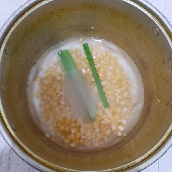 Masukkan jagung ke panci bersama air dan daun pandan. Kemudian masak jagungnya.