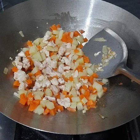 Untuk bahan isiannya panaskan minyak secukupnya lalu tumis bawang putih dan bawang bombai hingga wangi kemudian masukkan ayam cincang  dan aduk rata. Lalu tambahkan wortel dan kentang yang sudah di rebus sebelumnya.