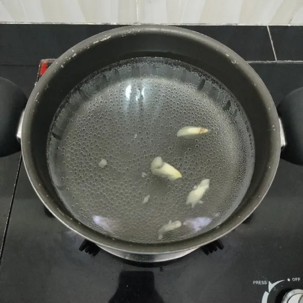 Rebus air dan bawang putih di dalam panci hingga mendidih.