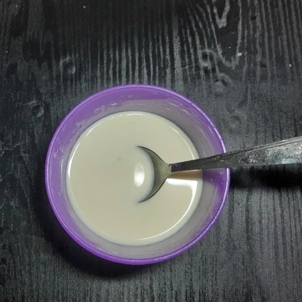 Masukkan susu bubuk kedalam wadah, campurkan dengan air hangat aduk rata dan sisihkan.