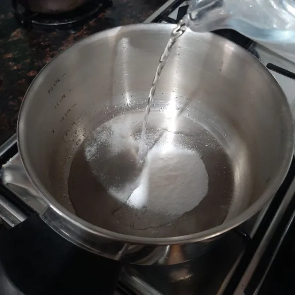 Aduk rata jeli dengan air dalam panci masak.