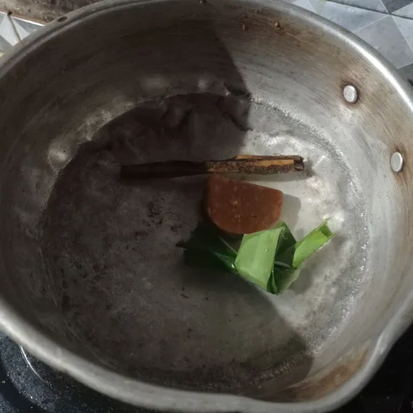 Masukkan air, gula merah, daun pandan dan kayu manis ke dalam panci.