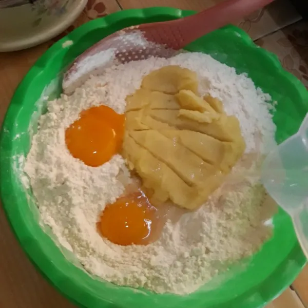 Tambahkan kuning telur, kentang dan air sedikit demi sedikit kemudian aduk hingga tercampur rata.