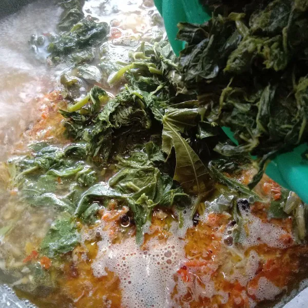 Masukkan daun singkong rebus, aduk rata. Tunggu mendidih.