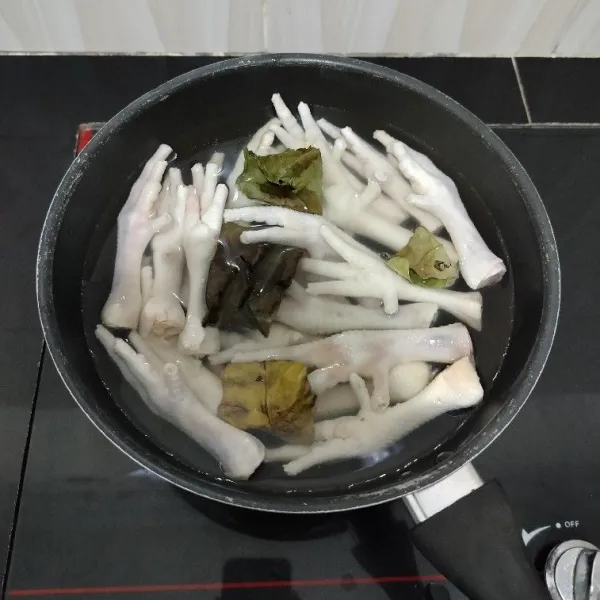 Bersihkan ceker ayam lalu rebus dengan air secukupnya dan daun salam hingga mendidih.