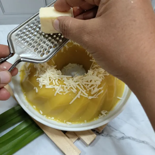 Setelah puding padat, lepaskan dari cetakan. Tambahkan keju parut sebagai toppingnya.