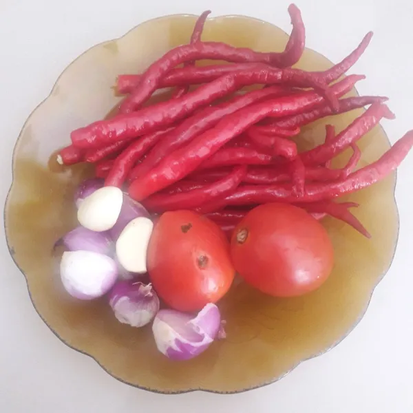 Siapkan bahan sambel lalu cuci bersih cabe dan tomat. Kupas dan iris-iris bawang merah dan bawang putih.