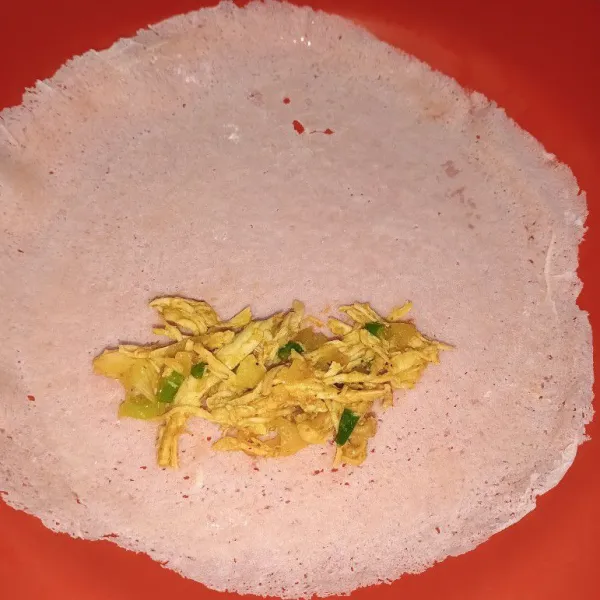 Taruh tumisan ayam tadi ke kulit lumpia, lipat memanjang.