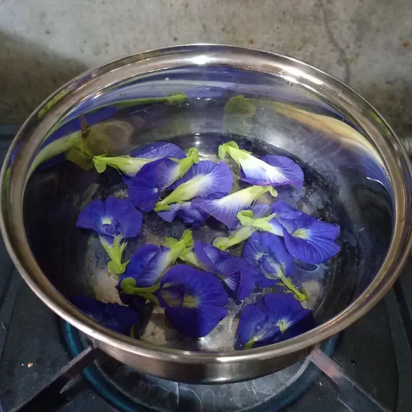 Rebus telang sampai mendidih kemudian tutup panci. Biarkan sampai warna telang luntur. Kemudian saring dan buang bunga telangnya.