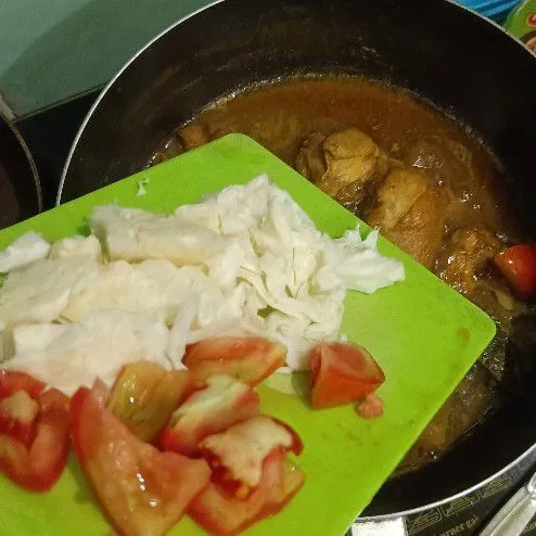Setelah ayam matang, masukkan irisan kol dan tomat, masak hingga sayuran matang.