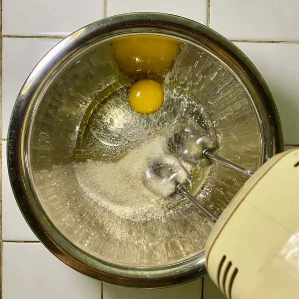 Siapkan wadah, lalu mixer telur dan gula pasir hingga rata.