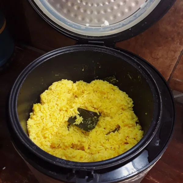 Masak hingga nasi kuning matang. Diamkan selama 30 menit, baru diaduk-aduk.