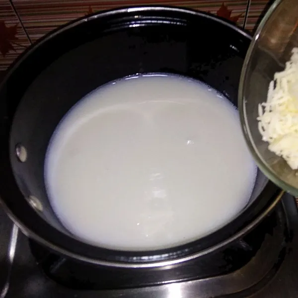 Siapkan panci, masukkan agar-agar, gula, keju bubuk, susu cair dan keju cheddar. Kemudian masak hingga mendidih.