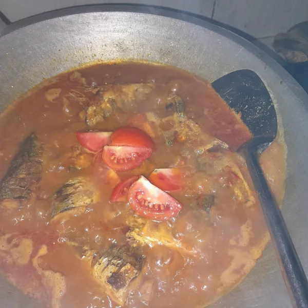 Lalu masukkan ikan yang sudah di goreng tadi dan tomat, aduk hingga rata. Masak hingga bumbu meresap.