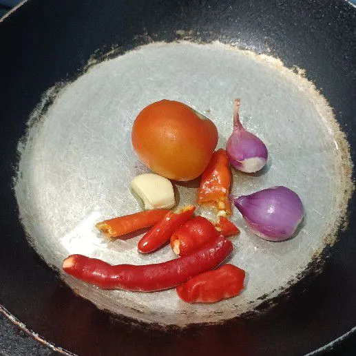 Goreng bawang putih, bawang merah, tomat, cabai rawit, serta cabai keriting dengan sedikit minyak asal layu.