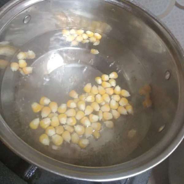 Dalam panci, didihkan air. Masukkan jagung, rebus sampai setengah matang.