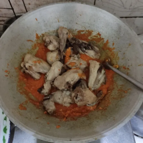 Masukkan ayam yang sudah digoreng setengah matang lalu aduk hingga ayam tercampur bumbu.