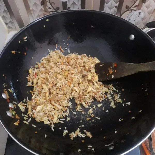 Masukkan nasi, tambahkan garam, kaldu jamur dan dedak rendang. Aduk-aduk terus sampai nasi goreng matang.