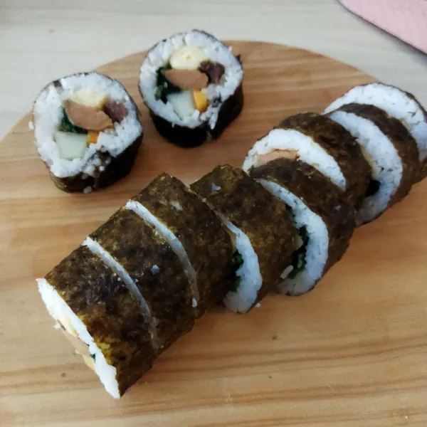 Potong-potong kimbab dengan pisau tajam yang telah diolesi air.