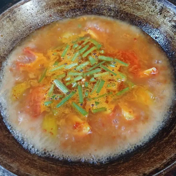 Beri air, didihkan. Masukkan tomat, belimbing dan bunga bawang.