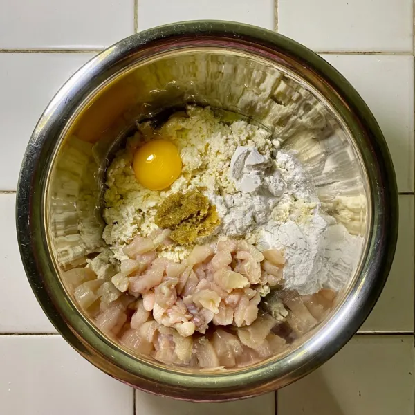 Siapkan wadah lalu tambahkan bumbu halus, tahu, telur, ayam, tepung tapioka, garam, lada bubuk dan kaldu bubuk. Aduk rata.