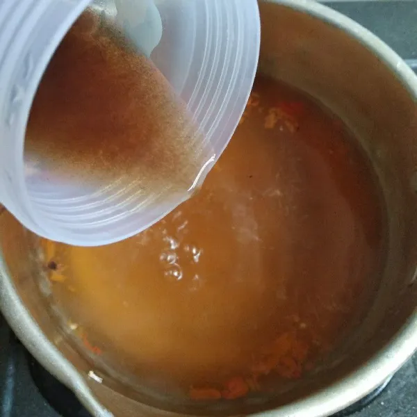 Masukkan air asam jawa, masak sampai mendidih. Matikan kompor lalu biarkan uap panasnya hilang.