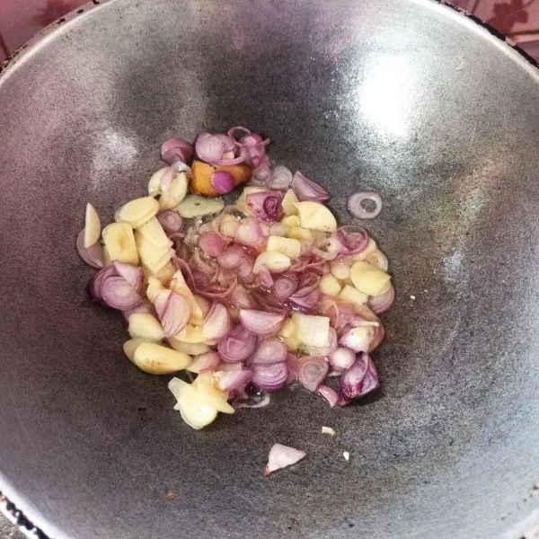 Tumis bawang merah, bawang putih dan lengkuas sampai harum dan matang.