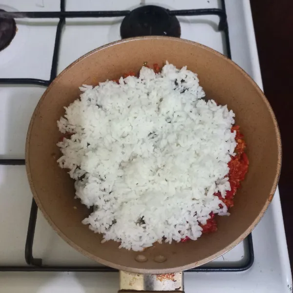 Masukkan nasi pada wajan, aduk rata.