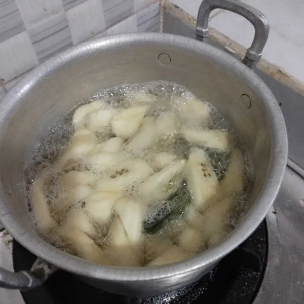 Masukkan potongan pisang ke air rebusan, aduk rata.