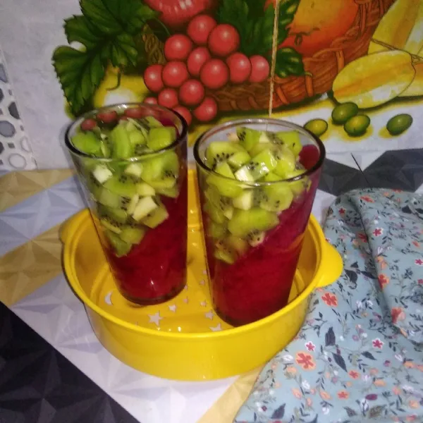 Tata potongan buah kiwi di atas puding buah naga, kemudian tuangi puding bening secara perlahan dan biarkan hingga padat. Siap untuk disajikan.