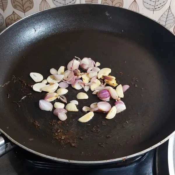 Sisakan sedikit minyak di wajan bekas menggoreng ikan tadi. Masukkan bawang putih dan bawang merah. Tumis hingga harum.