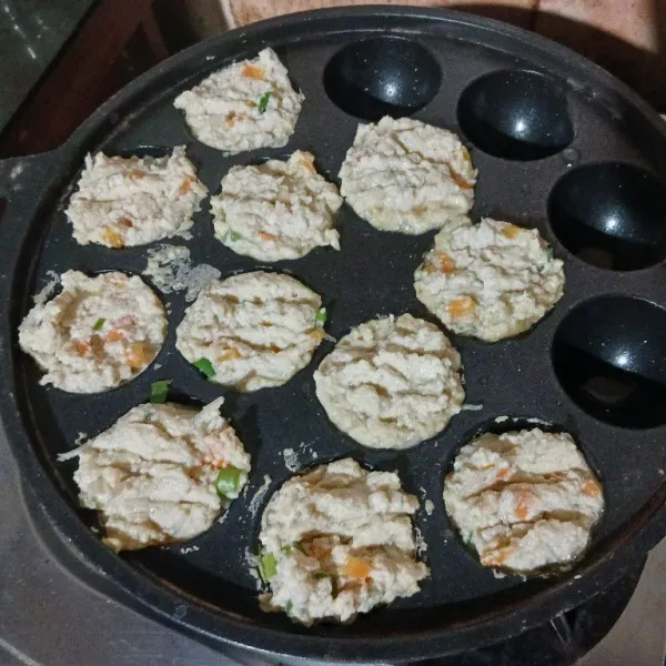 Panaskan pan takoyaki. Oles dengan minyak goreng. Beri tahu hingga penuh.