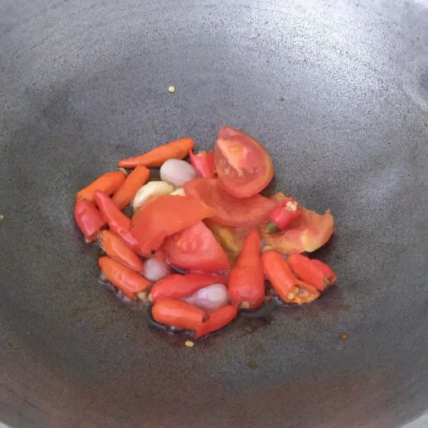 Goreng bawang merah, bawang putih, cabai, dan tomat sampai layu.