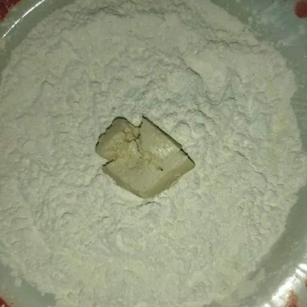 Campur tepung tapioka, garam, kaldu bubuk dan lada bubuk, aduk rata, lalu balur tahu yang sudah digeprek dengan tepung tapioka.