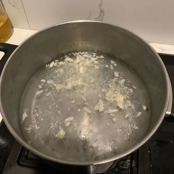 Rebus air, masukkan jahe dan bawang putih yang sudah dicincang.
