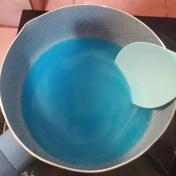 Campur bubuk jelly, gula pasir, dan air. Lalu beri pewarna biru sedikit saja (gunakan tusuk gigi supaya tidak berlebihan pewarnanya). Aduk rata, lalu rebus sampai mendidih. Angkat.
Aduk-aduk supaya uap panasnya hilang.