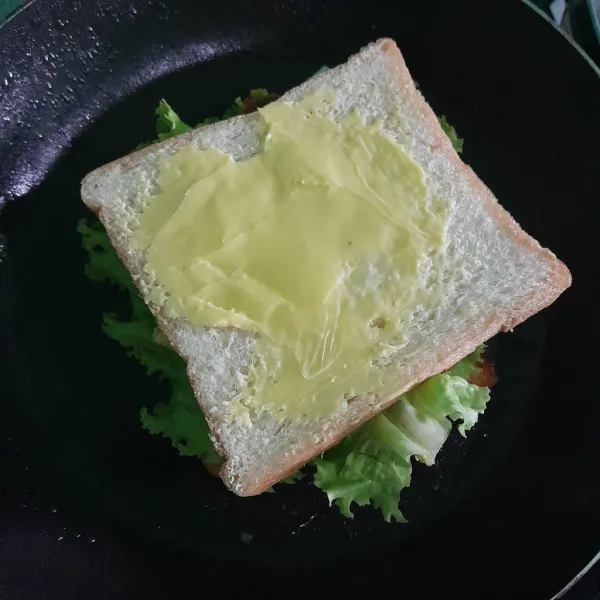 Tutup kembali dengan roti yang sudah dioles margarin, lalu balik dan panggang hingga roti nampak kecokelatan.