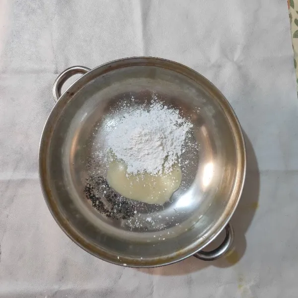 Siapkan wadah, masukkan tepung tapioka dan krimer kental manis.
