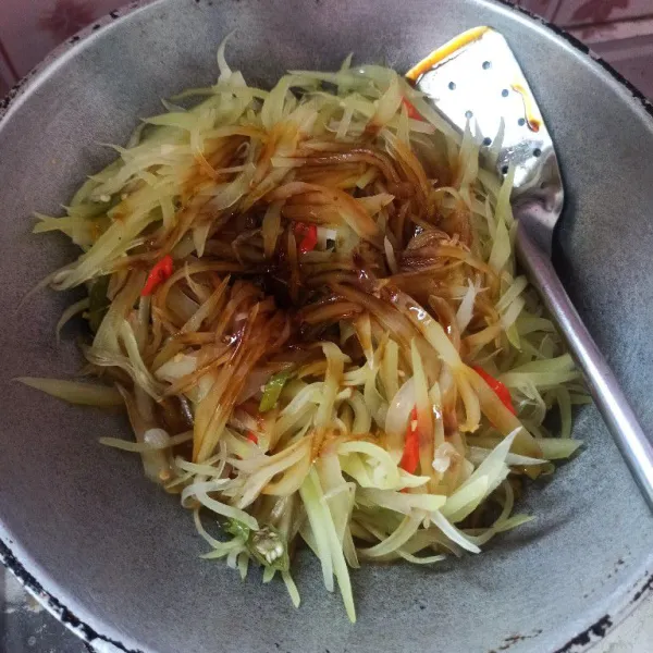 Selanjutnya masukkan kecap manis, aduk hingga tercampur rata dan pepaya matang.